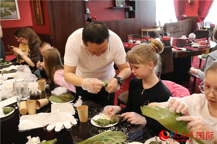 烏克蘭兒童學習體驗包粽子。人民網(wǎng)記者蔡子暢攝